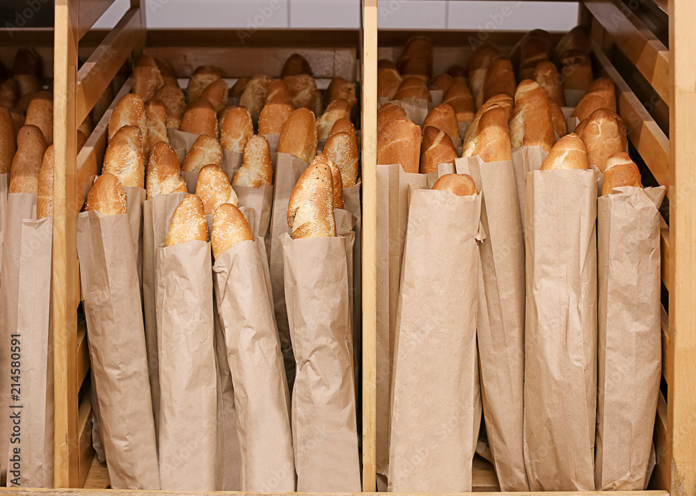 Tasty fresh baguettes on shelf in bakery