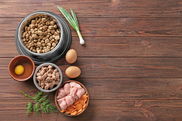 Wall Mural - Bowls with pet food and natural products on wooden background