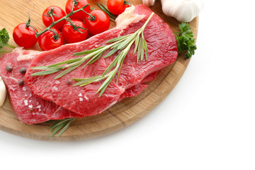 Wooden board with raw meat, vegetables and spices on white background