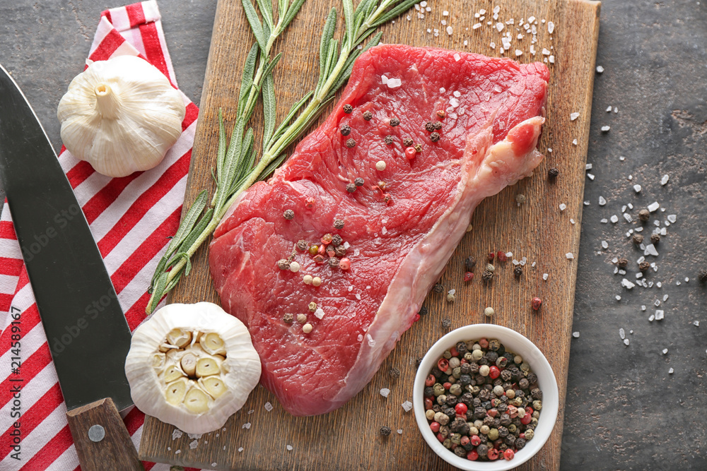 Fresh raw meat with spices on wooden board