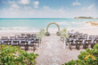 Beautiful beach wedding venue setting with flowers, floral decoration on arch, panoramic ocean view