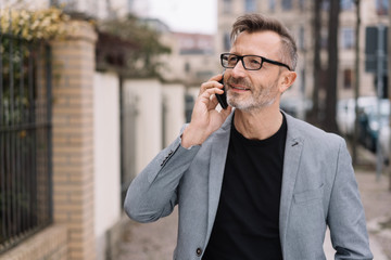 Wall Mural - Businessman standing in an urban street