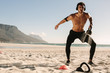 © Jacob Lund - Man doing fitness training at the beach with kettlebells