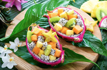 Exotic Fruit Salad Served In Half A Dragon Fruit On Palm Leaves