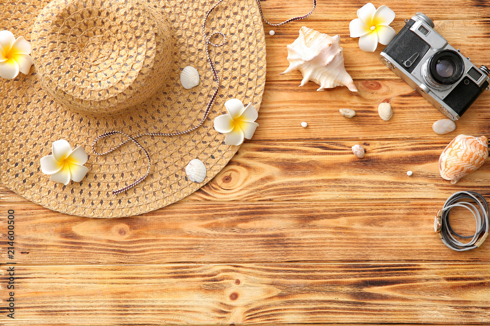 Composition with photo camera, female accessories and seashells on wooden background