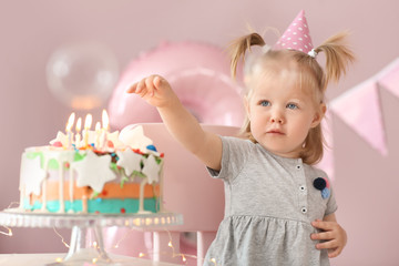 Wall Mural - Cute little girl with birthday cake sitting on chair in room