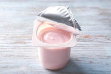 Plastic Cup With Yummy Strawberry Yogurt On Wooden Background