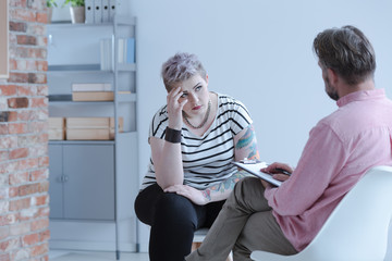 Fototapete - Rebellious young girl with lack of self-acceptance and drug addiction problem during an individual psychotherapy session with an intervention specialist.oppositional defiant disorder,