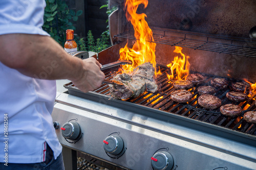 Fotomural Man cooking barbecue with flames in a UK garden