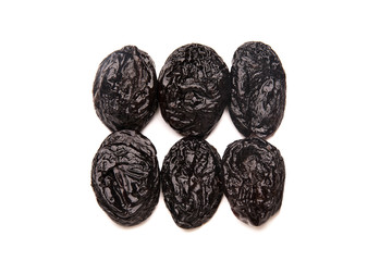 Prunes arranged in two rows isolated on a white background