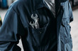 cropped view of workman in overalls with wrenches in pocket