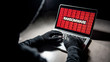 © zephyr_p - Male hacker hand on laptop computer keyboard with red binary screen of ransomware attacking. Cyber attack and Internet data security concept