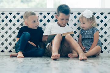 Sticker - children read a book on the bed