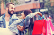 © Kalim - Portrait of happy couple with shopping bags after shopping in city