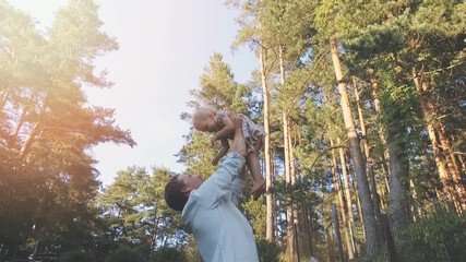 Wall Mural - loving dad playing with his daughter at home backyard. father lifting little girl