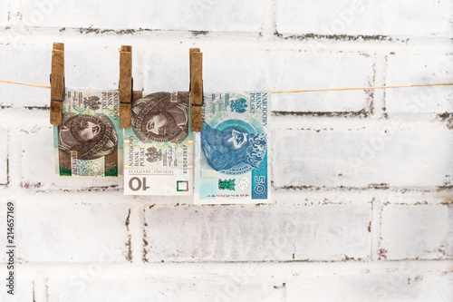 Fotografía Three Polish zloty bills attached with old wooden washing clips hanging on the s