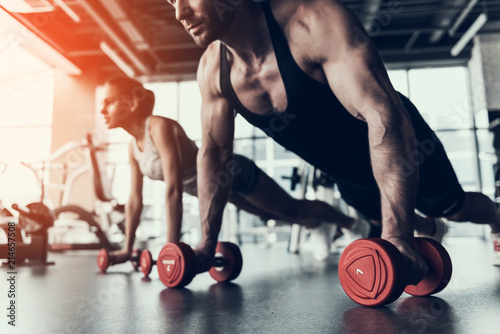 Cuadros en Lienzo Young Man and Woman Training in Fitness Club.