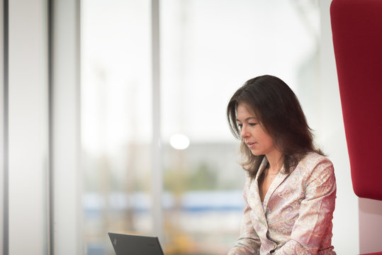 Concentrated female graphic designer working at laptop computer on new project during remote job in coworking space.Pensive copywriter typing text on netbook connected to wireless 4G internet
