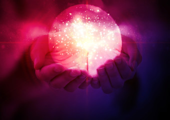 Wall Mural - magic glowing ball with a flash of light in women's hands on an abstract dark background.