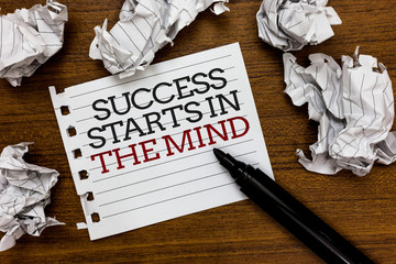 Text sign showing Success Starts In The Mind. Conceptual photo Have positive thoughts accomplish what you want Paper lumps laid randomly around white notepad touch black pen on woody floor.