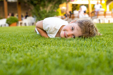 smiling girl laying in the grass on a summer day and having fun