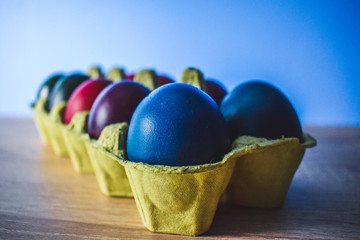 Wall Mural - Color Easter Eggs on Wooden Background