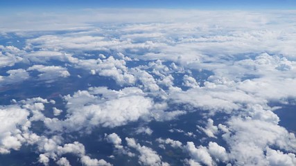 Wall Mural - flying over picturesque bright white and blue cloudscape. beautiful moving clouds view from airplane
