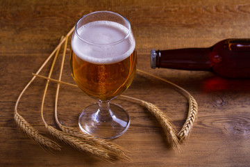 Wall Mural - Glass and bottle of beer, ears of barley on wooden table. Ale