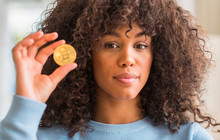 African American Woman Holding Golden Bitcoin Cryptocurrency At Home With A Confident Expression On Smart Face Thinking Serious