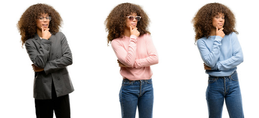 Poster - African american young woman wearing different outfits looking confident at the camera with smile with crossed arms and hand raised on chin. Thinking positive.