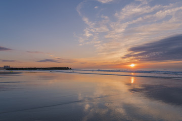 Colorful sunrise over Avon By The Sea beach in New Jersey featuring dramatic sky on the background and sky reflection on the foreground