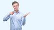 © Krakenimages.com - Young handsome blond man very happy pointing with hand and finger