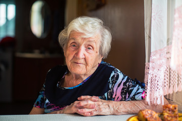 Portrait of an elderly woman sitting at the table.