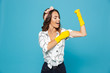 © Drobot Dean - Photo of attractive strong woman 20s showing bicep while wearing yellow rubber gloves for hands protection during housework, isolated over blue background