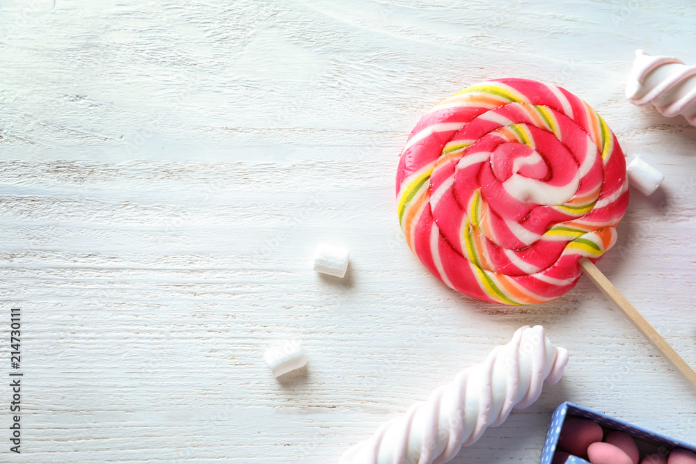 Colorful lollipop with marshmallows on light wooden background
