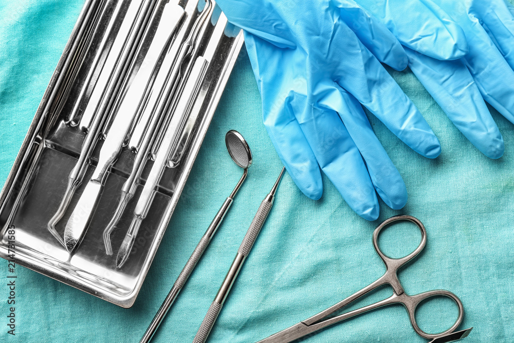Tray with dentist's tools and gloves on fabric