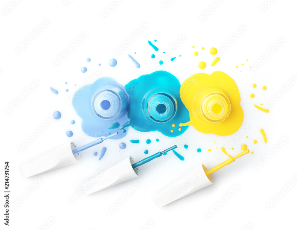 Open bottles of nail polishes with brushes on white background