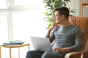 Young freelancer using laptop at home