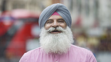 Portrait Of Senior Indian Man In A Turban Smiling To Camera On The Street