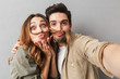 © Drobot Dean - Portrait of a funny young couple hugging taking a selfie