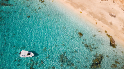 Wall Mural - Small motor boat anchoring at sandy beach