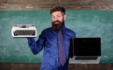 Digital against retro. Choose right teaching method. Teacher choosing teaching approach. Modern technologies benefit. Modern instead outdated. Teacher bearded hipster holds typewriter and laptop