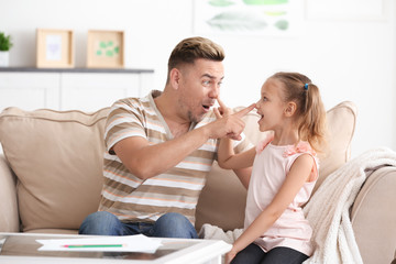 Happy father and daughter playing at home