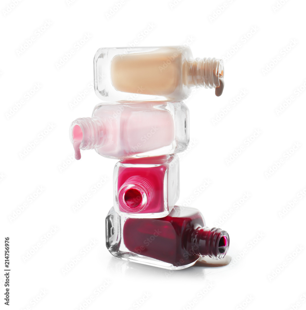 Open bottles of nail polishes on white background