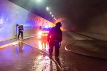 Car Accident Scene Inside A Tunnel, Firefighters Rescuing People From Cars