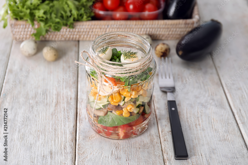 Delicious vegetable salad in jar on wooden table