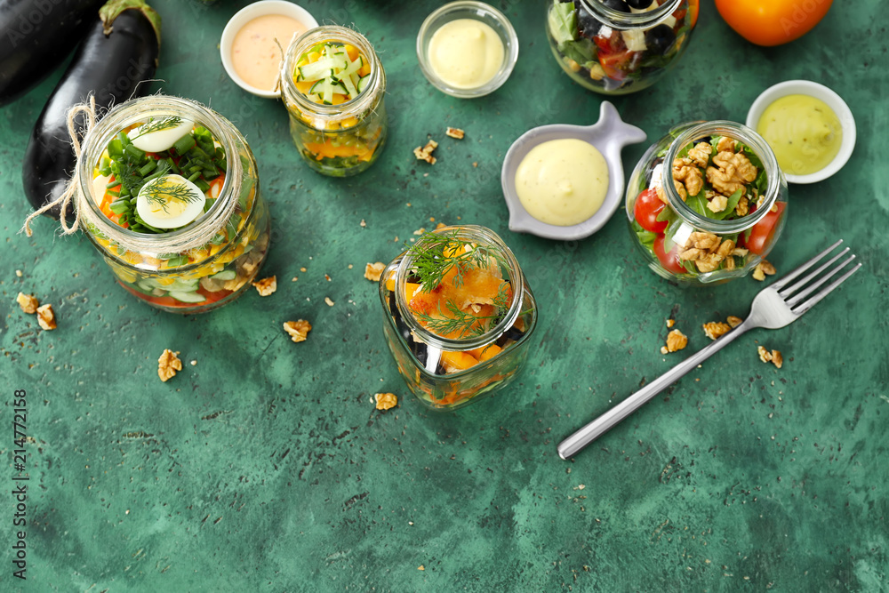 Composition with delicious vegetable salad in jars on table