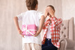 © Pixel-Shot - Cute little boy hiding gift for his mother behind back