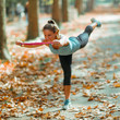 © Microgen - Woman Exercising With Elastic Band Outdoors in The Fall