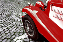 Front Side Part Of Vintage Classic Red Hot Rod Car On A Cobble Road